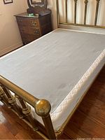 Double mattress fitted on a brass bed frame to show size and condition. Mattress surface is flat and clean with no visible wear.