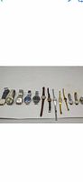 Photo showing 11 vintage his and hers wristwatches arranged in a row, various band and dial styles visible