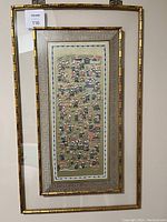 Framed embroidered silk artwork with 100 children playing, view of entire piece showing bamboo-style frame and matting