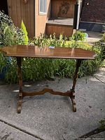 Full front view of antique wood hall table, showing polished top surface and turned leg design.