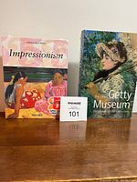 Photo showing front covers of two sealed art books: "Impressionism" by Taschen and "The J. Paul Getty Museum Handbook of the Collection".