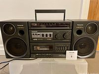 Front view of the Panasonic RX-CS780 boom box showing radio tuner, cassette player, controls, and speakers.