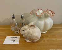Photo showing set of four cut crystal salt and pepper shakers, Cybis porcelain bunny figurine, and white vase with pink ruffled top