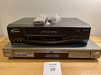 Photo showing Misaki VHS player and Samsung DVD player stacked, with remote and cables on top.