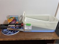 Overall view of all items showing ceramic trivet, Tupperware loaf container with insert, Pot Luck recipe deck, and Wusthof carver knife.