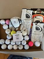 Photo showing four white ladies right handed golf gloves with Callaway branding and selection of used golf balls in various colors including white, yellow, and pink, plus some branded PowerBilt balls.