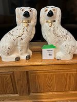 Pair of large white ceramic Beswick mantle dogs with gold collars and chain designs painted. Both dogs sit upright and have black noses and orange eyes.