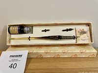 Full view of the pen set including the pen, ink bottle, two nibs and certificate inside the original box with branded lid.