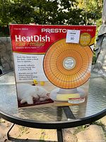 Photo of the Presto HeatDish Plus Footlight space heater in its original box, showing product image, branding and features.