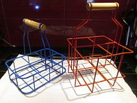 Two plastic-coated wire baskets, one blue and one red, with wooden handles, visible in their full size and shape.