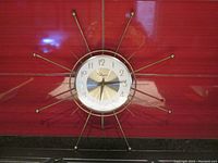 Full view of the Ingraham sunburst atomic wall clock showing overall design and size with metallic rods extending from clock face.