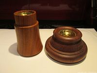 Pair of Dansk wooden candle holders on white surface, showing overall shape and brass candle cup inserts.