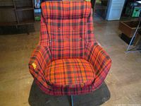 Front view showing high back, padded arms, removable cushion and plaid upholstery