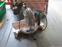 Side angle view of Black and Decker mitre saw showing handle, base, and dust collection bag.