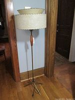Full view of the vintage mid century floor lamp showing two-tier fiberglass shade and wooden brass pole