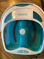 HoMedics brand footbath massager device in blue and white, showing internal soaking area with massager and control buttons.