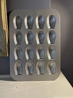 Top view of non-stick madeleine pan showing 15 shell-shaped cavities arranged in rows