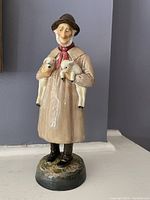 Clear photo of a Royal Doulton porcelain shepherd figurine holding two lambs, showing the front details and painted finish.