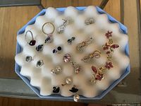 Collection of earrings and rings displayed on foam tray view one