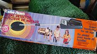 Photo of original box for the Radio Shack deluxe metal detector showing colorful graphics with family outdoors and image of the metal detector's coil and control unit.
