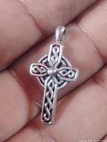 Front view of a sterling silver Celtic cross pendant showing detailed knotwork and central bead.