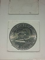 Reverse side showing Liberty Bell with the moon in the background, inscriptions UNITED STATES OF AMERICA and ONE DOLLAR.