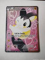 Full view of Emolga full art holo foil Pokémon card with pink heart background and 70 HP on top right.