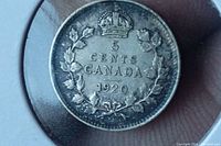 Reverse side of 1920 Canadian 5 cent silver coin showing denomination, country, and date surrounded by a wreath and crown.