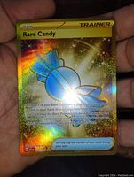 Front view of a Rare Candy holographic foil Pokémon Trainer card featuring intense gold and rainbow sparkles.