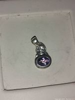 Front view of the oval amethyst pendant in sterling silver on a white background.