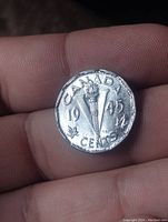 Front side of 1945 Canada V nickel showing torch with maple leaves and year '1945'