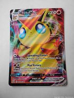Clear photo of holographic Victini VMAX full art Pokemon card showing front side details and holographic shine.