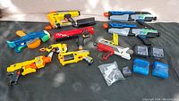 Overview of assorted Nerf blasters and magazines arranged on a black surface