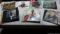 Photo showing a variety of vinyl record covers for artists including Rita Coolidge, Eric Clapton, Joe Cocker, Charlie Daniels Band, and Carole King. Covers with visible wear and discoloration, some moisture marks.