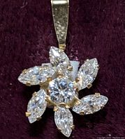 Close-up of 10K gold floral pendant showing stones and prong settings