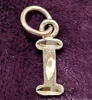 Close-up front view of the 10K gold letter I pendant charm showing texture and polished facets.
