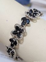 Close-up image of sapphire and sterling silver flower-shaped cluster links of bracelet