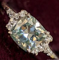 Close-up front angled view of sterling silver ring with cushion-cut 1.35ct moissanite and clear accent stones