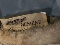Close-up photo showing the label with 'Genuine Canadian Mink' wording sewn inside the hat and edge of mink fur.
