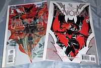 Photo showing two Batwoman comic books, one colorful and one black, white, and red cover.