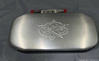 Closed metal case with engraved wildcat or mascot logo on lid