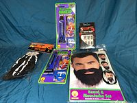 Full lot overview showing beard set, skeleton gloves, two packs of blue cream makeup, and zombie nails