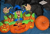 Two hanging bats with green faces and adjustable wings next to an orange pumpkin Brew sign centerpiece