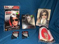 Full lot display including three wigs and two sets of zombie nails on blue fabric background.