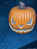 Front view of the jack-o-lantern showing the carved face and ridged pumpkin body with stem.