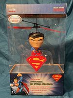Front view of the RC Flying Superman toy in original packaging showing the toy figure with rotor blades and Superman branding.