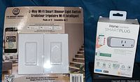 Box of CE Smart Home 3-Way Wi-Fi Smart Dimmer Light Switch pack of two and iHome Control Smart Plug box.