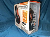 Tritton Katana HD headset in original retail packaging showing headset and wireless transmitter images, branding, and feature callouts including HDMI and 7.1 surround sound.