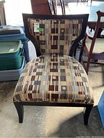 Front view showing the geometric patterned upholstery and wooden legs.