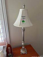 Full view of the table lamp showing its height, metal base, and fabric shade.